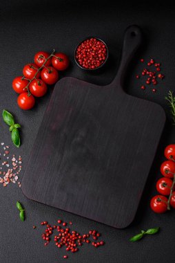 Koyu beton zeminde domates, tuz, baharat ve otlar pişirmek için gerekli malzemeler.