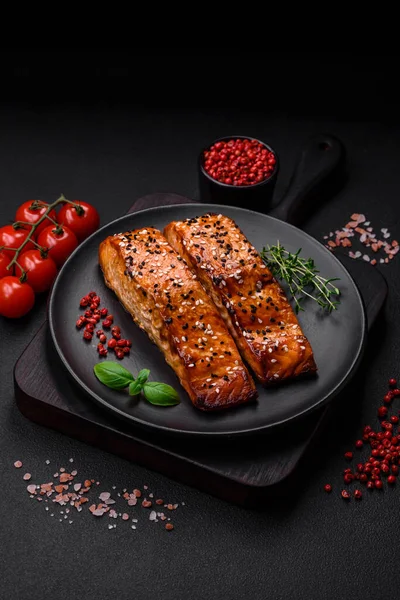 Stock image Delicious fresh grilled red fish with salt, spices and herbs on a dark concrete background