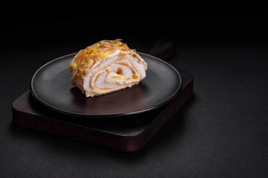 Lezzetli, taze, tatlı kremalı krema, badem cipsi, fındık ve böğürtlen dilimleri koyu beton arka planda kesilmiş.