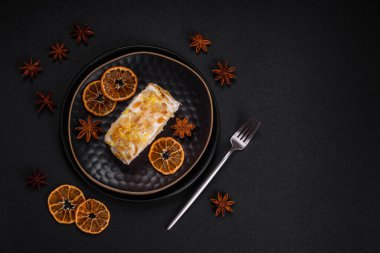 Lezzetli, taze, tatlı kremalı krema, badem cipsi, fındık ve böğürtlen dilimleri koyu beton arka planda kesilmiş.