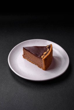 Lezzetli, taze, fındıklı çikolatalı pasta. Koyu beton arka planda dilimler halinde kesilmiş.