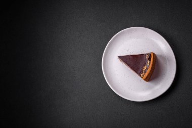 Lezzetli, taze, fındıklı çikolatalı pasta. Koyu beton arka planda dilimler halinde kesilmiş.