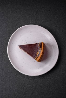 Lezzetli, taze, fındıklı çikolatalı pasta. Koyu beton arka planda dilimler halinde kesilmiş.