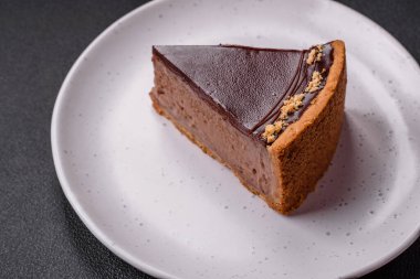 Lezzetli, taze, fındıklı çikolatalı pasta. Koyu beton arka planda dilimler halinde kesilmiş.