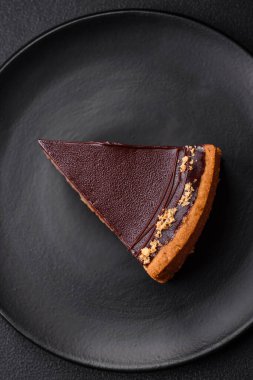 Lezzetli, taze, fındıklı çikolatalı pasta. Koyu beton arka planda dilimler halinde kesilmiş.