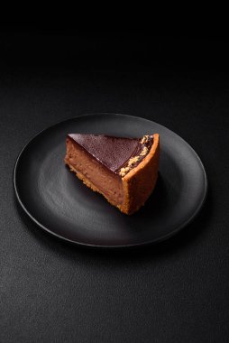 Lezzetli, taze, fındıklı çikolatalı pasta. Koyu beton arka planda dilimler halinde kesilmiş.