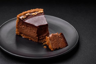 Lezzetli, taze, fındıklı çikolatalı pasta. Koyu beton arka planda dilimler halinde kesilmiş.