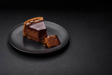 Lezzetli, taze, fındıklı çikolatalı pasta. Koyu beton arka planda dilimler halinde kesilmiş.