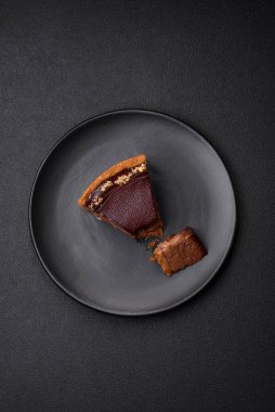 Lezzetli, taze, fındıklı çikolatalı pasta. Koyu beton arka planda dilimler halinde kesilmiş.