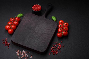 Koyu beton zeminde domates, tuz, baharat ve otlar pişirmek için gerekli malzemeler.