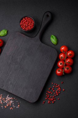 Koyu beton zeminde domates, tuz, baharat ve otlar pişirmek için gerekli malzemeler.