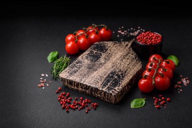 Koyu beton zeminde domates, tuz, baharat ve otlar pişirmek için gerekli malzemeler.