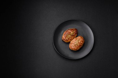 Lezzetli taze kıymalı balık pirzolası. Esmer arka planda baharatlar ve otlarla birlikte.