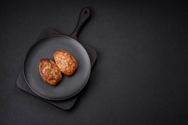 Lezzetli taze kıymalı balık pirzolası. Esmer arka planda baharatlar ve otlarla birlikte.