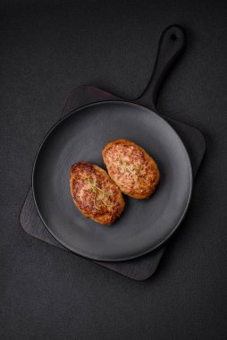 Lezzetli taze kıymalı balık pirzolası. Esmer arka planda baharatlar ve otlarla birlikte.