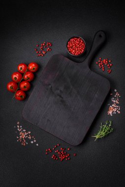 Koyu beton zeminde domates, tuz, baharat ve otlar pişirmek için gerekli malzemeler.