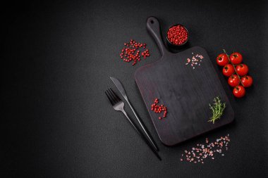 Koyu beton zeminde domates, tuz, baharat ve otlar pişirmek için gerekli malzemeler.