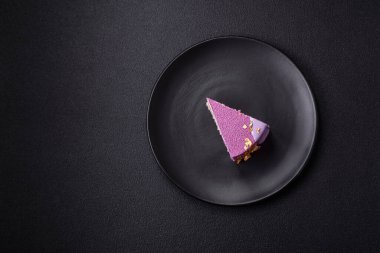 Koyu beton arka planda pembe kadife kaplamalı böğürtlenli leziz taze kremalı pasta.