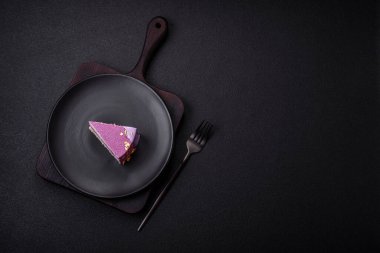 Koyu beton arka planda pembe kadife kaplamalı böğürtlenli leziz taze kremalı pasta.