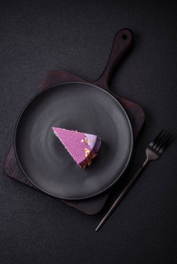 Koyu beton arka planda pembe kadife kaplamalı böğürtlenli leziz taze kremalı pasta.