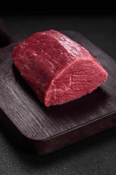 濃いテクスチャのコンクリートの背景に塩 スパイス ハーブでジューシーな新鮮な生牛肉 — ストック写真