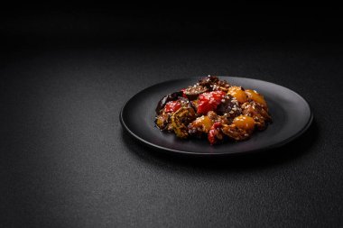 Lezzetli taze salata fırında patlıcan, domates, tatlı biber, susam tohumu, baharat ve koyu beton arka planda tuz.