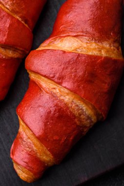 Lezzetli, çıtır çıtır, kırmızı kruvasan kremalı koyu desenli beton arka plan.