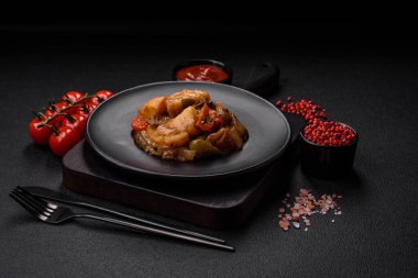 Lezzetli taze patates güveci, domates, soğan, havuç ve tuzlu et, baharat ve çimento arka planda bulunan otlar.