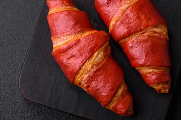 Lezzetli, çıtır çıtır, kırmızı kruvasan kremalı koyu desenli beton arka plan.