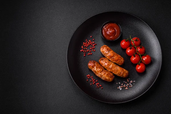 stock image Delicious juicy grilled sausages with salt, spices and herbs on a dark concrete background