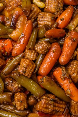 Sebze karışımı mısır, havuç, biber, brokoli, teriyaki soslu soğan koyu beton arka planda seramik bir tabakta