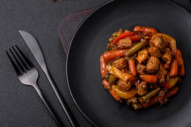 Sebze karışımı mısır, havuç, biber, brokoli, teriyaki soslu soğan koyu beton arka planda seramik bir tabakta