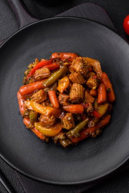 Sebze karışımı mısır, havuç, biber, brokoli, teriyaki soslu soğan koyu beton arka planda seramik bir tabakta