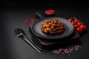 Sebze karışımı mısır, havuç, biber, brokoli, teriyaki soslu soğan koyu beton arka planda seramik bir tabakta