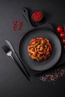 Sebze karışımı mısır, havuç, biber, brokoli, teriyaki soslu soğan koyu beton arka planda seramik bir tabakta