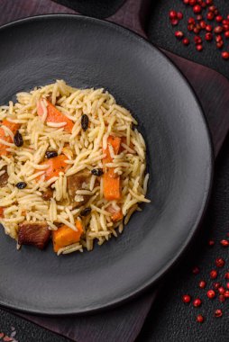 Koyu beton arka planda tavuk, havuç, böğürtlen, baharat ve bitkilerle nefis Özbek pilavı