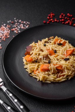 Koyu beton arka planda tavuk, havuç, böğürtlen, baharat ve bitkilerle nefis Özbek pilavı