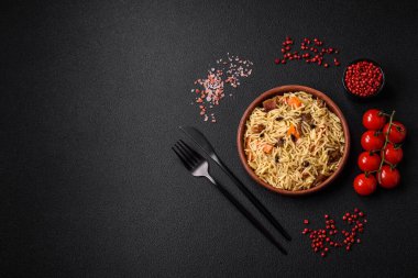 Koyu beton arka planda tavuk, havuç, böğürtlen, baharat ve bitkilerle nefis Özbek pilavı