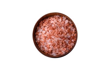 Pink himalayan salt in a wooden bowl on a dark concrete background. Seasonings and additives in the kitchen