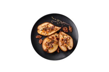 Delicious baked pear with dorblu cheese, walnut and honey on a textured concrete background. Vegetarian dish