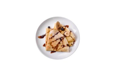 Delicious fresh baked pancakes with honey and fruits on a textured concrete background. Useful healthy food