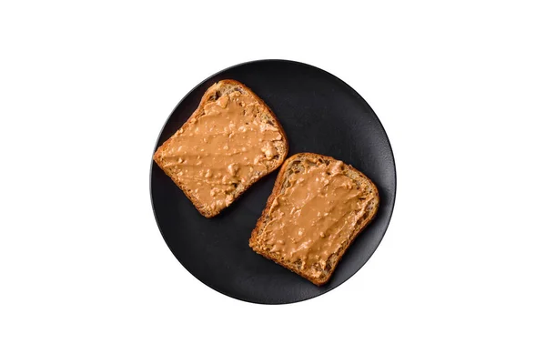Sándwich Nutritivo Compuesto Pan Mantequilla Cacahuete Sobre Plato Cerámica Negra —  Fotos de Stock