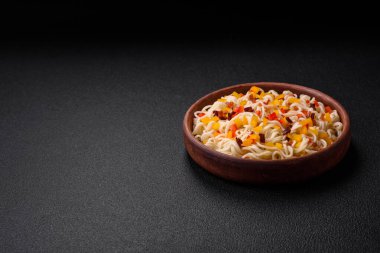 Lezzetli taze Asya erişteleri, sebze parçaları, et, tuz, baharat ve otlarla birlikte koyu beton bir arka planda.