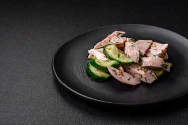 Lezzetli taze salatalık ve ızgara tavuk dilimleri, Fransız hardalı, tuz ve baharatları koyu beton arka planda.