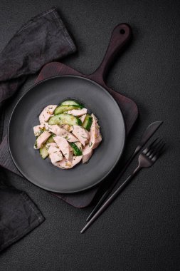 Lezzetli taze salatalık ve ızgara tavuk dilimleri, Fransız hardalı, tuz ve baharatları koyu beton arka planda.