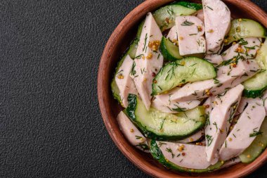 Lezzetli taze salatalık ve ızgara tavuk dilimleri, Fransız hardalı, tuz ve baharatları koyu beton arka planda.