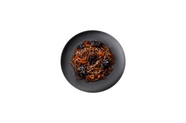 Lezzetli taze karabuğday eriştesi ya da mantarlı udon, biber ve diğer sebzeler, baharatlar ve otlar koyu beton arka planda.