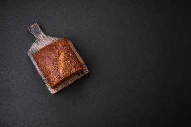 Koyu beton arka planda tahıl ve çekirdekli lezzetli çıtır kahverengi ekmek.