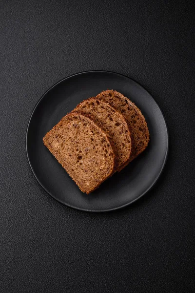 带有谷粒和种子的美味新鲜脆红面包 背景为深色混凝土 — 图库照片