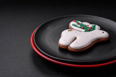 Seramik tabaklar, zencefilli çörekler ve koyu beton arkaplanda yeni yıl süslemelerinin diğer unsurlarından oluşan güzel bir Noel kompozisyonu